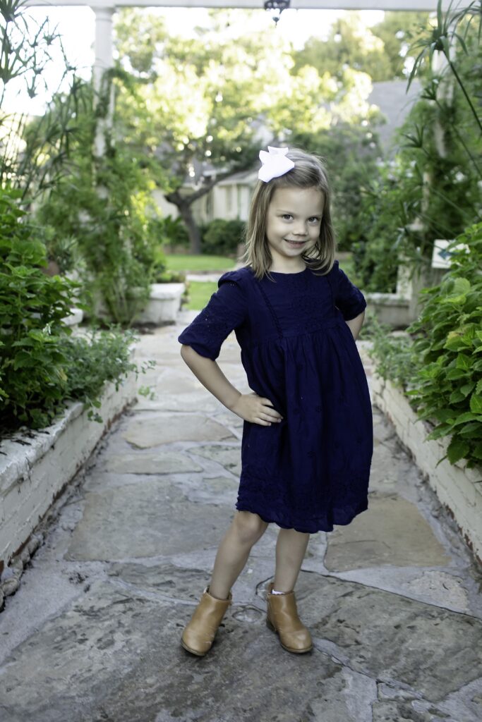 The oldest sister posing confidently, surrounded by the serene beauty of Chandor Gardens