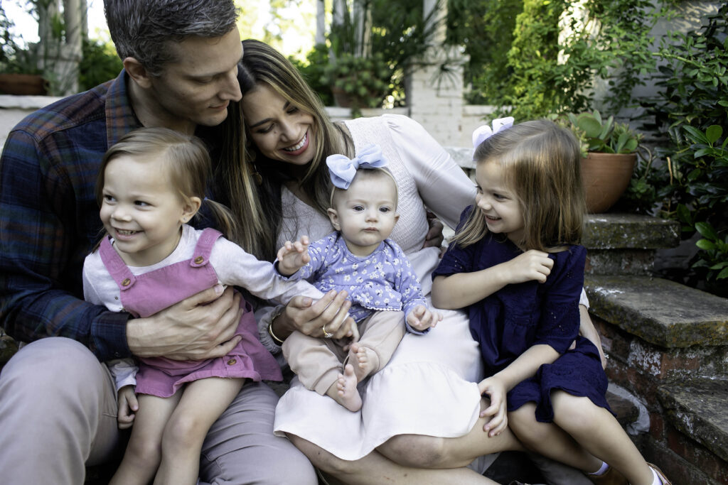 Family sharing a heartfelt embrace in the stunning garden setting of Chandor.