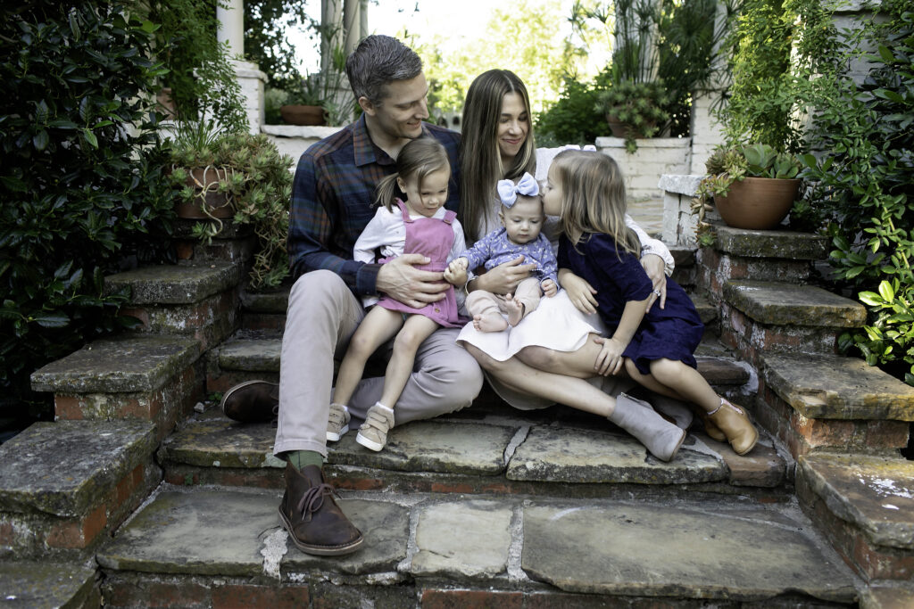 Family posing together in the beautiful, lush landscape of Chandor Gardens