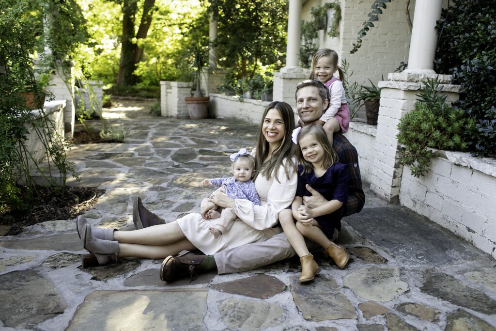 Family of five sharing a sweet moment in the vibrant, natural beauty of Chandor Gardens