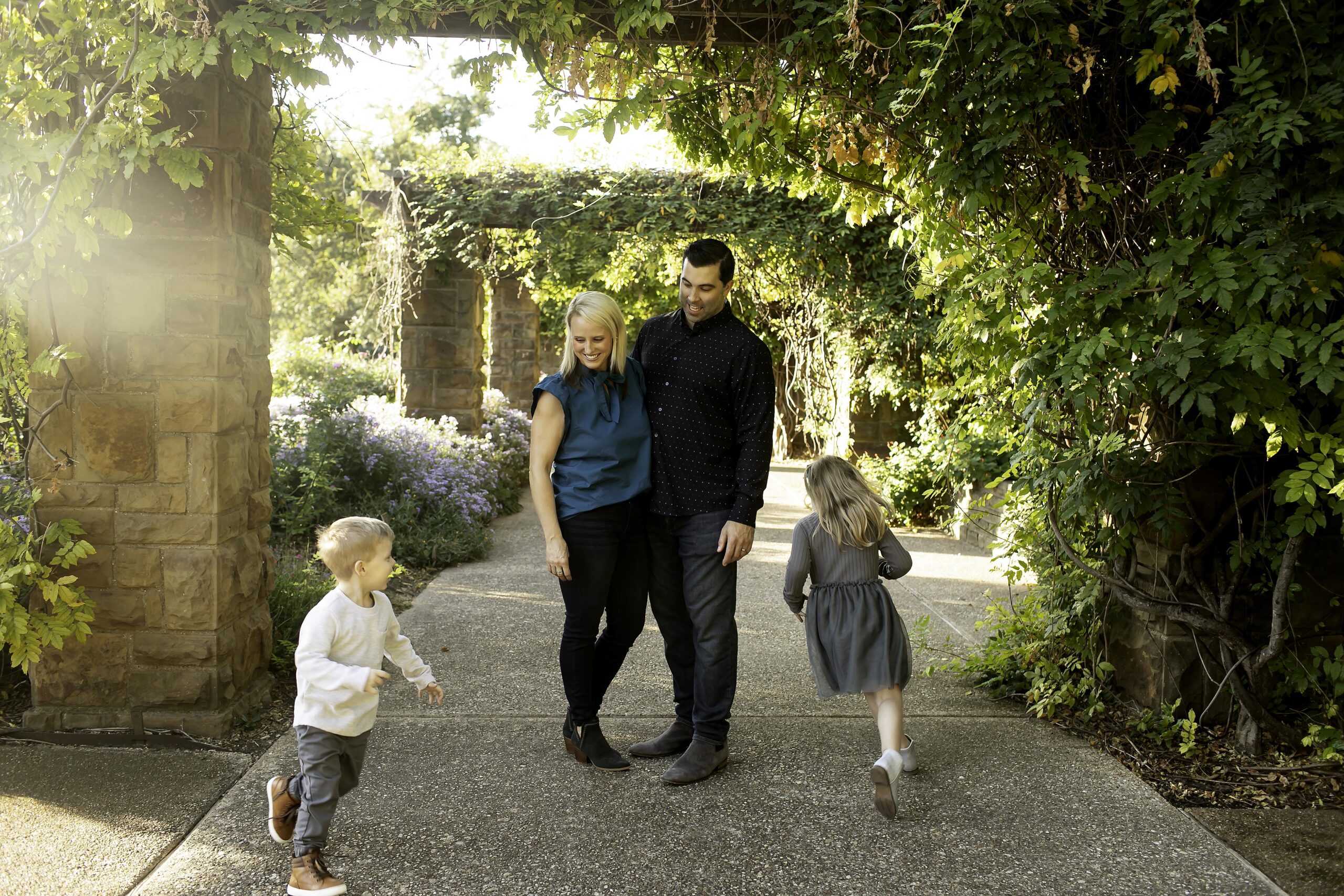 Parents watching their kids happily run around them in a playful family moment captured during a Chunky Monkey Photography session