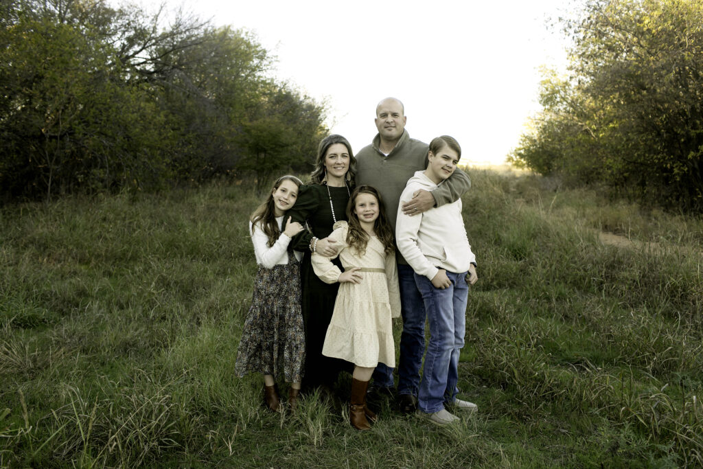 Parents and children standing together at Northwest Community Park, surrounded by trees and natural beauty