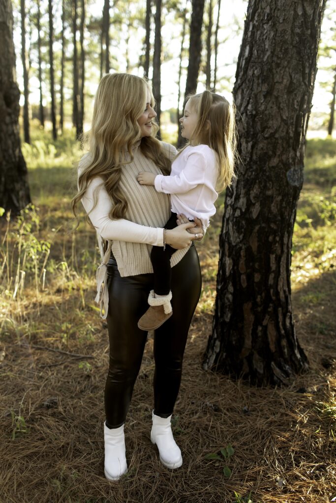 Captured in Decatur, a mom and her 3-year-old walk hand-in-hand through the lush pine trees, creating a heartwarming family moment in the great outdoors.