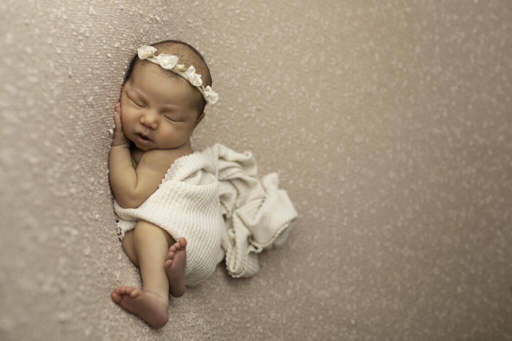 A peaceful newborn resting on a soft blanket, captured in a serene moment by Chunky Monkey Photography