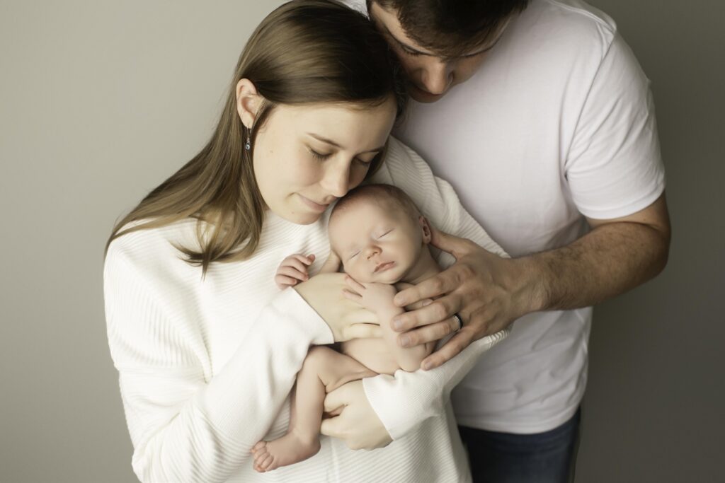 Newborn boy snuggled with mom, sharing a peaceful moment filled with warmth and love