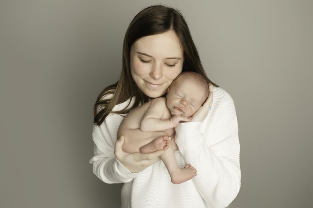 Newborn boy peacefully posing with his mom, capturing a tender moment of love and connection