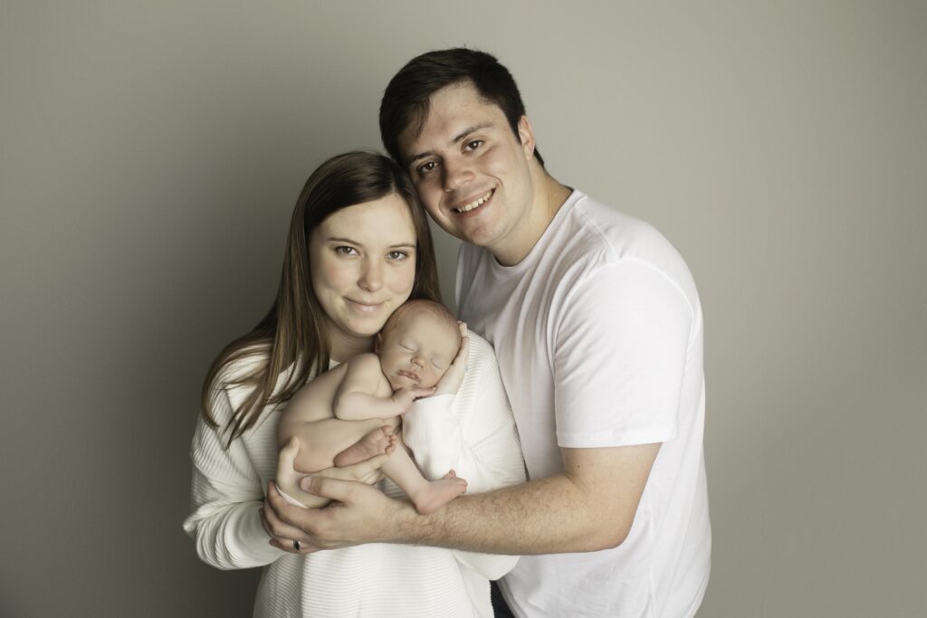 Newborn boy with mom and dad, posing together as a beautiful family, full of love and joy