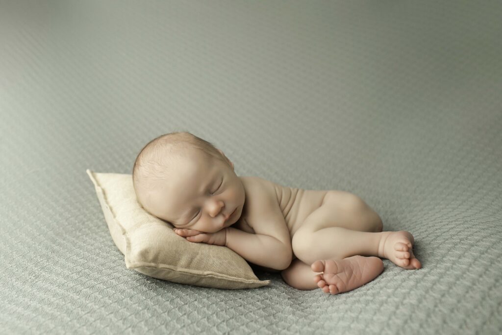 Newborn baby boy sleeping peacefully on a soft blanket during a Chunky Monkey Photography session