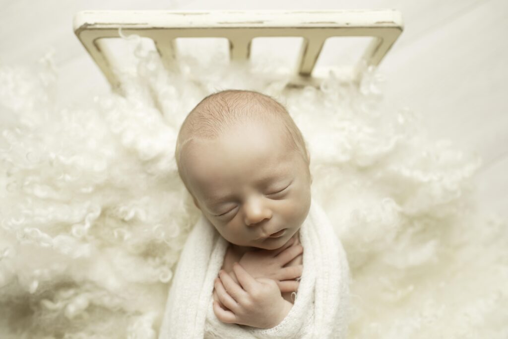 Close-up of a newborn baby boy's tiny hands and feet, captured with gentle lighting