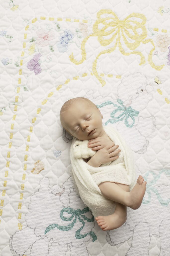 dorable newborn boy resting gently on a plush blanket, surrounded by cozy, serene lighting