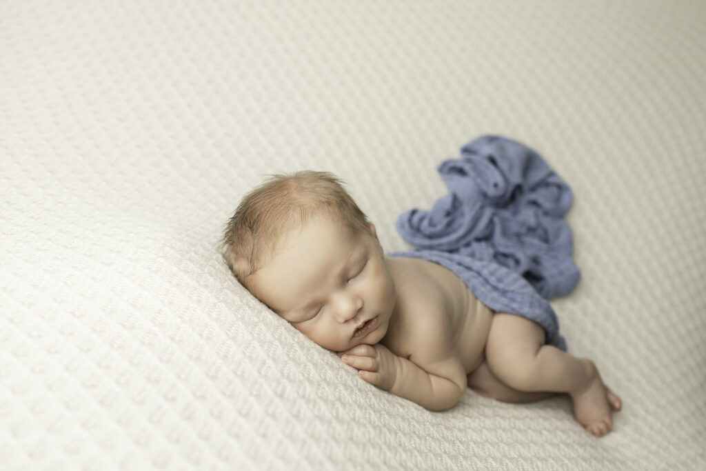 A sweet newborn girl lying on a fluffy blanket, surrounded by softness, beautifully shot