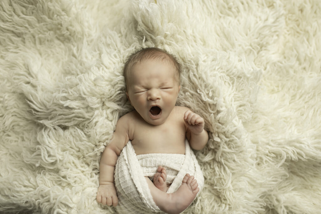 A timeless moment with a sleeping newborn, wrapped in soft fabrics, captured gently