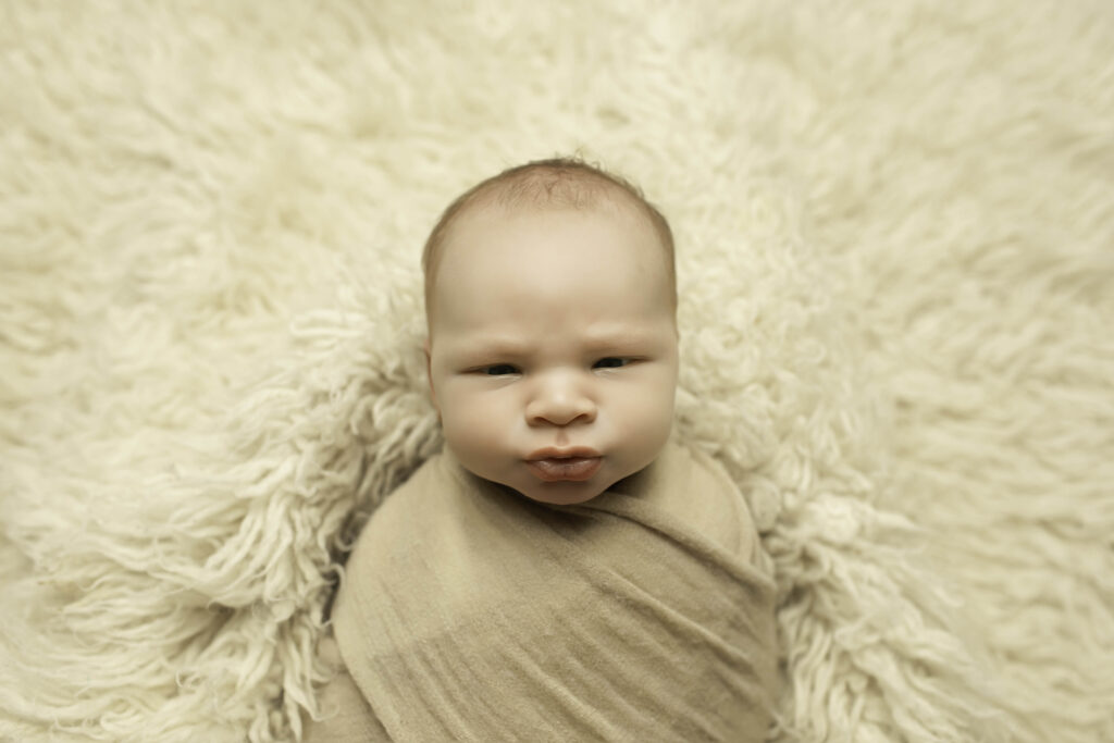 Close-up of a newborn boy’s tiny hands and feet, highlighting his delicate features