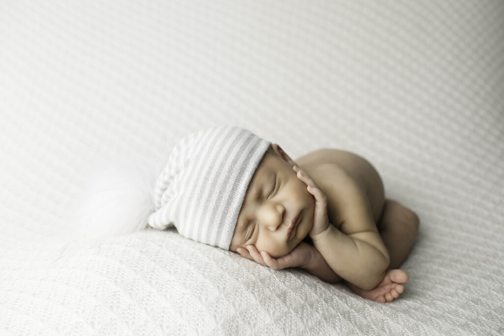 Newborn baby boy peacefully sleeping on a soft, cozy blanket in a studio setting