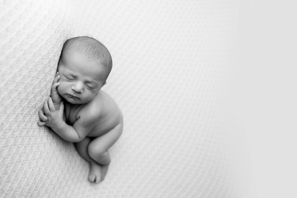 Newborn baby boy peacefully sleeping in a cozy studio setting