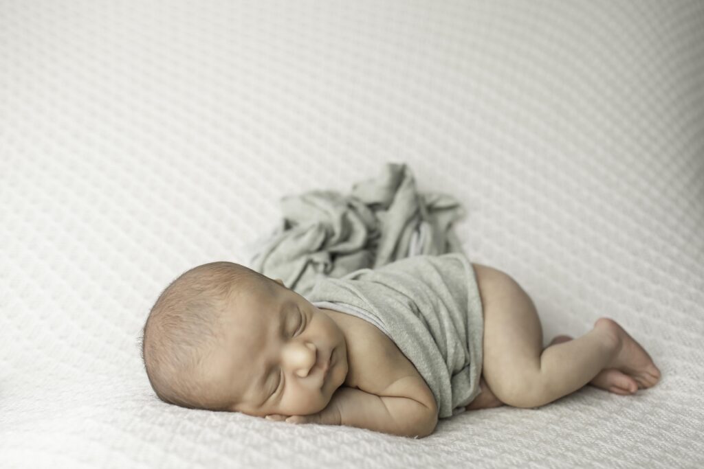 Adorable newborn baby boy sleeping soundly on a plush blanket