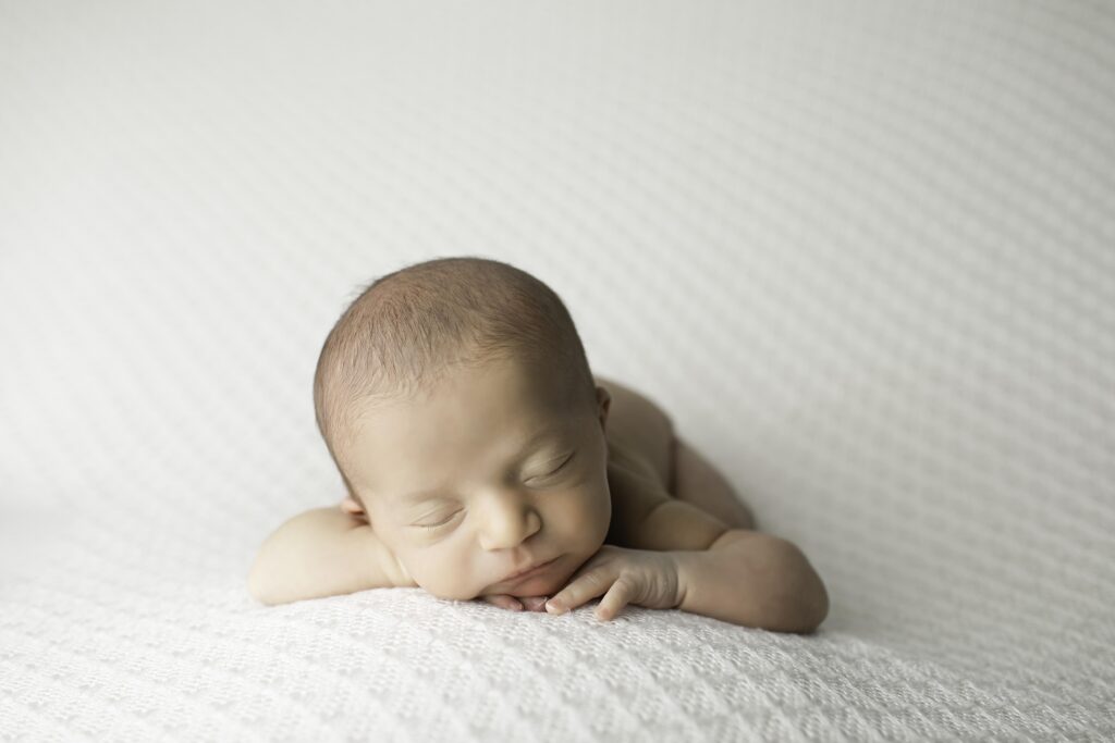 Cute newborn baby boy in a peaceful sleep, surrounded by soft fabrics