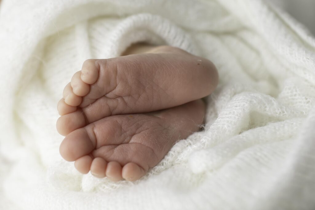 Close-up of newborn baby boy's tiny toes, captured in a soft, serene setting during a Chunky Monkey Photography session