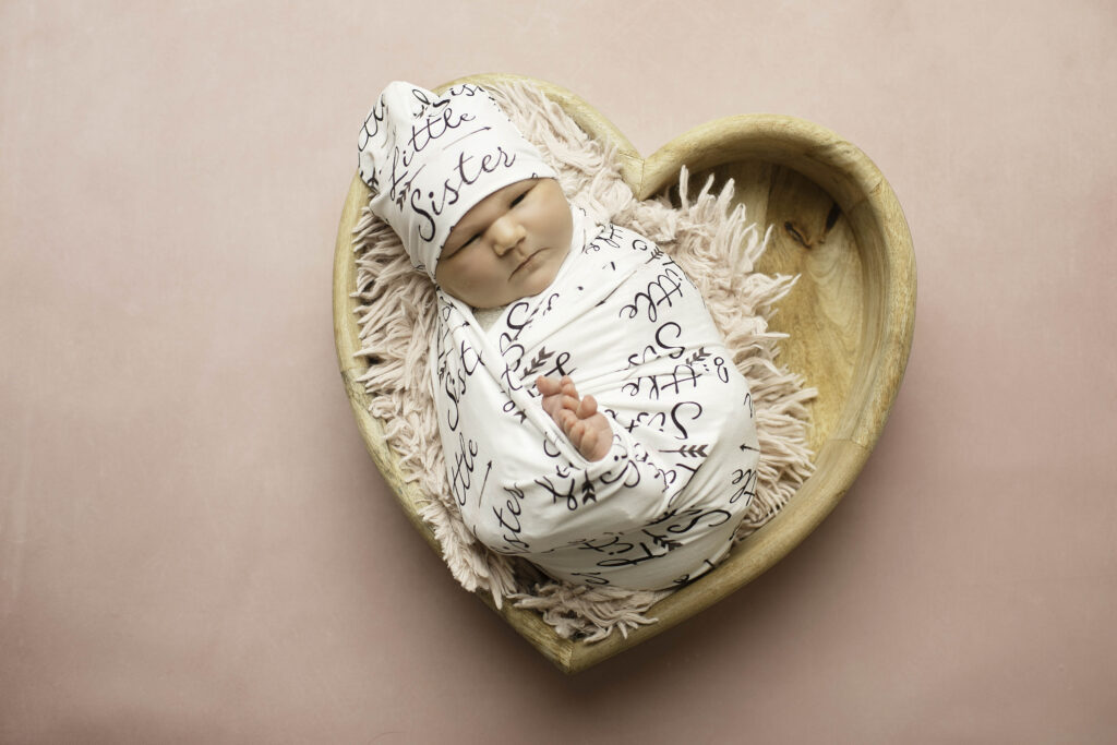 A close-up shot of a newborn girl, peacefully sleeping in a delicate knit blanket, her tiny features soft and serene