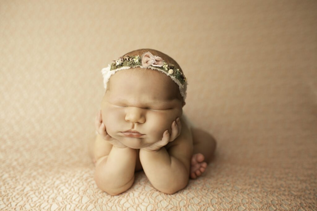 A close-up shot of a newborn with adorable chunky cheeks, peacefully sleeping on a soft blanket during a cozy photoshoot