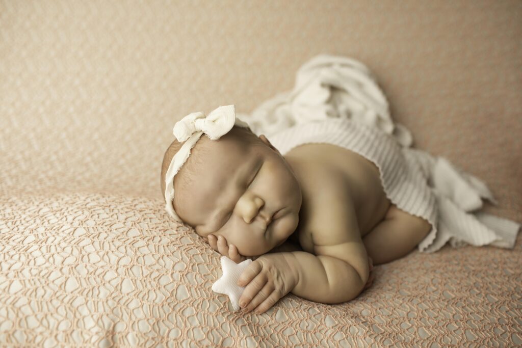 A newborn with round, adorable cheeks and tiny fingers is bundled in a cozy blanket, creating a peaceful, heartwarming scene