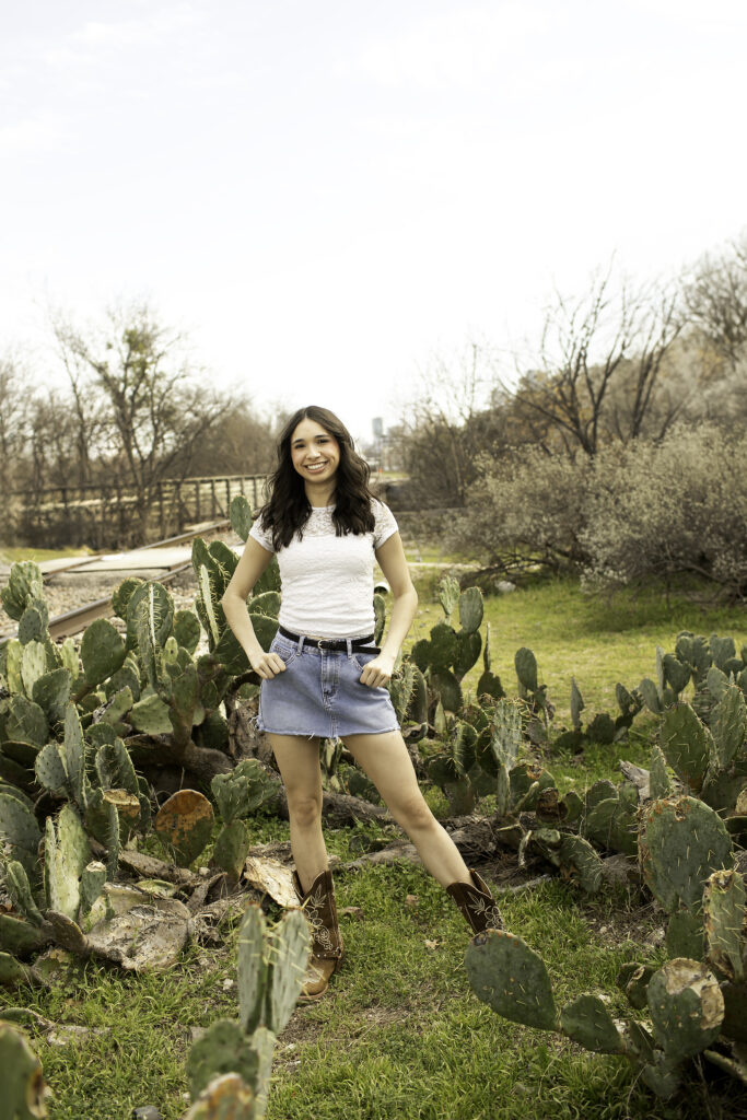 A candid shot of senior girl walking through the Cactus Garden, her laughter captured in the warm sunlight.